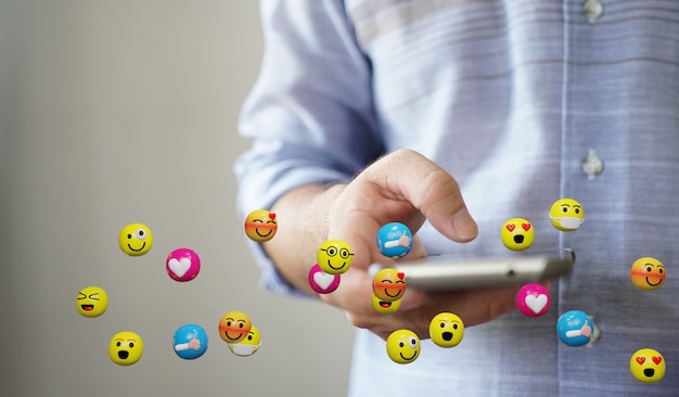 Man met smartphone verzenden van tekstberichten emoticon pictogrammen. Social media concept, 3D-rendering