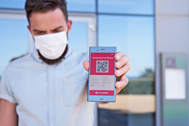 Man met smartphone weergegeven op app mobiel verlopen digitaal vaccinatiecertificaat voor Covid19