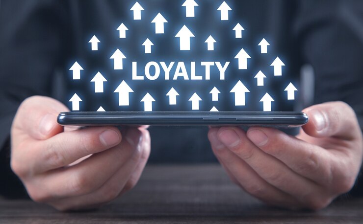 Man met smartphone. Word loyaliteit met een groeiende pijlen. Loyaliteit vergroten