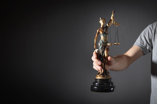 Man met standbeeld van Vrouwe Justitia Law