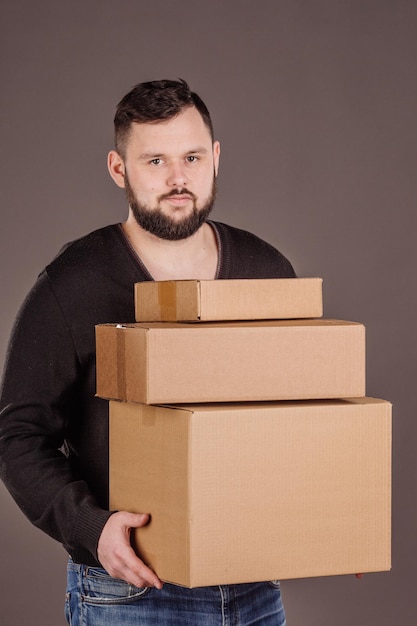 Man met stapel kartonnen dozen vooraan