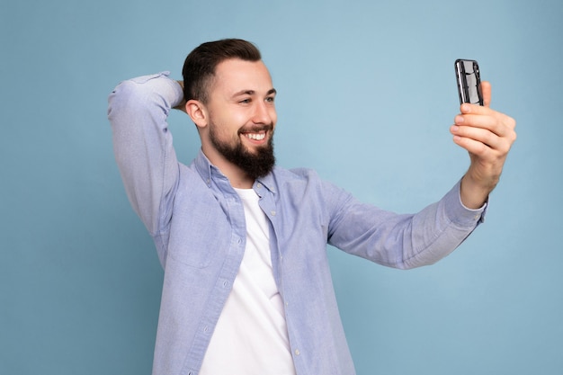 man met stijlvolle casual kleding permanent geïsoleerd dan blauw