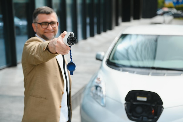 Man met stroomconnector voor elektrische auto