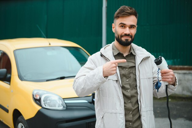 Man met stroomconnector voor elektrische auto