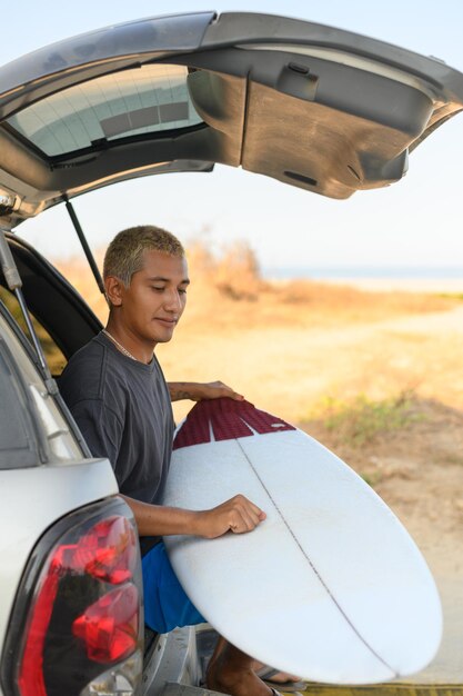 Man met surfplank in de auto.