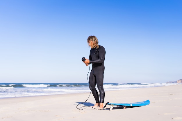 man met surfplank op de oceaan kust. Surfer in een nat pak