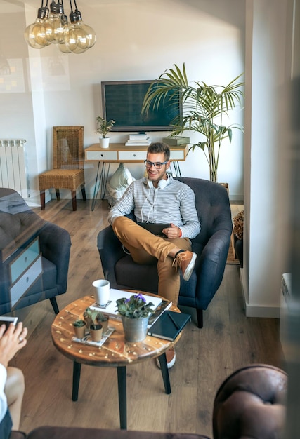 Man met tablet in een wachtkamer in gesprek met iemand