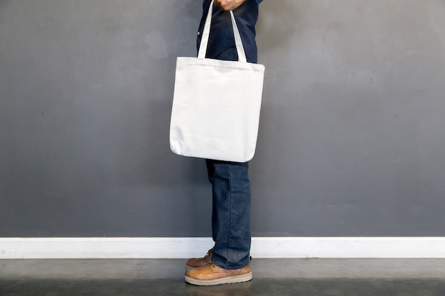 Man met tas canvas stof voor mockup, ecologie concept.