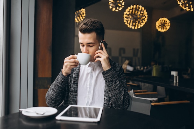 Man met telefoon en tablet in een acfe