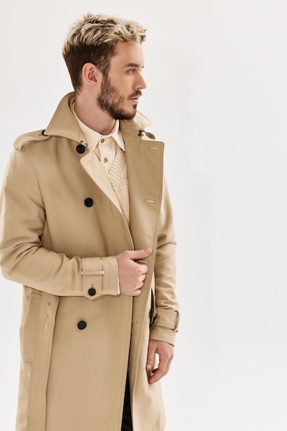 Man met trendy kapsel in beige jas moderne stijl herfstkleding