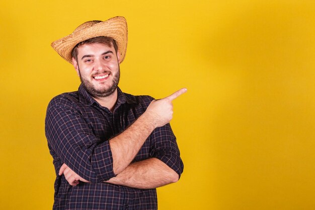 Man met typische kleding voor Festa Junina Feest van Arraia de Sao Joao Wijsvinger wijzend naar de zijkant tekst of reclame