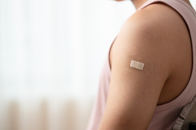 Man met verband die zijn arm laat zien na het ontvangen van vaccin