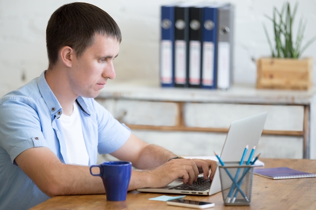 Man met vermoeide gezicht op een laptop