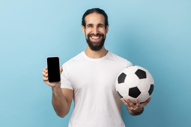 Man met voetbal en smartphone lege zwarte display ticket boeking voor kampioenschap