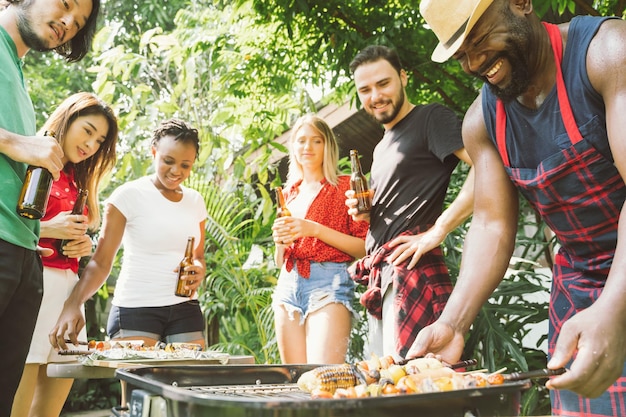 Man met vrienden die eten bereiden op de barbecue