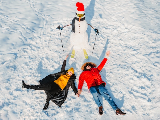 Man met vrouw in de buurt van skiër sneeuwpop winteractiviteiten