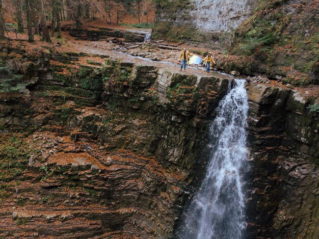 Man met vrouw met Oekraïense vlag op de top van de waterval