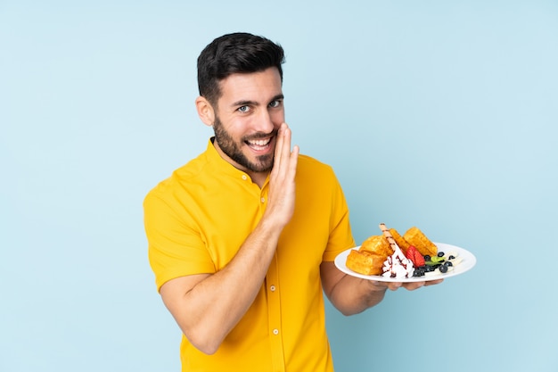 Man met wafels op blauw iets fluisteren