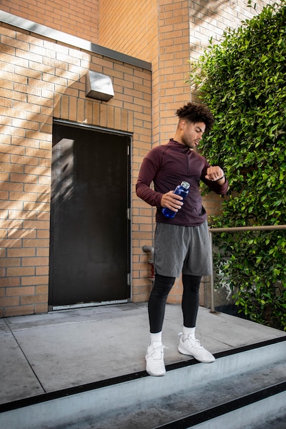 Foto man met water van de fles bij het joggen