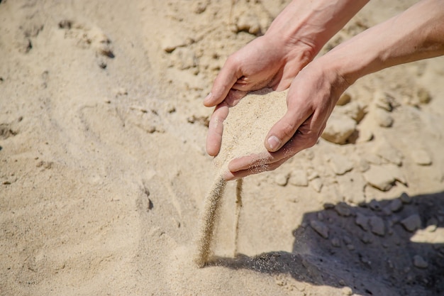 Man met zand in zijn handen