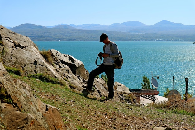 Man met zijn camera klaar voor het maken van foto's op het Sevan-schiereiland, het Sevanmeer, Armenië