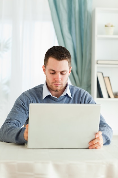 Man met zijn laptop in zijn thuiskantoor