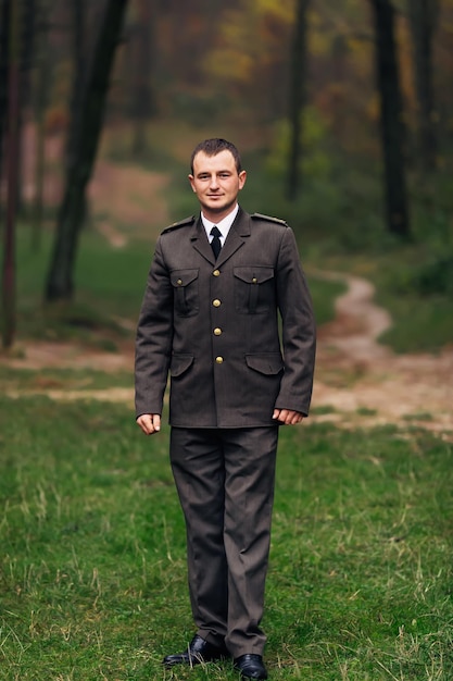 Foto uomo in uniforme militare che guarda la telecamera che cammina nella pa