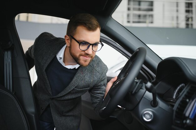 Man minded customer male buyer client in suit choose auto to go look aside want buy new automobile in car showroom vehicle salon dealership store motor show indoor Sales concept