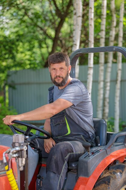 A man on a mini-excavator levels a piece of land loosens the soil