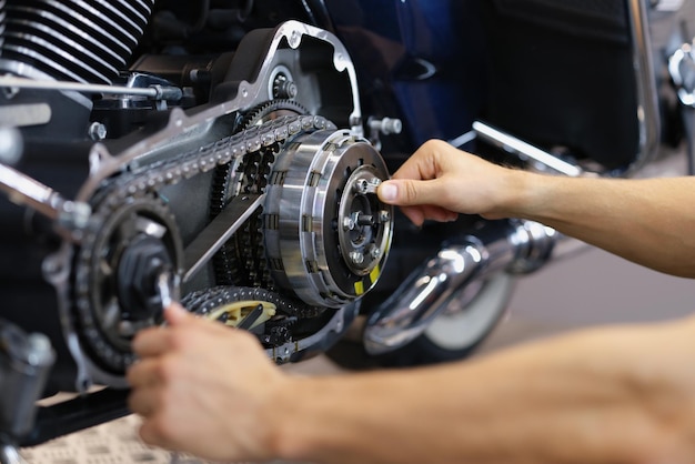 Man monteur werken met schroevendraaier en reparatie motorfiets detail
