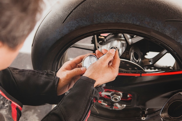 Man collaudo manuale della pressione dell'aria dei pneumatici per motocicli prima di viaggiare per un veicolo di sicurezza