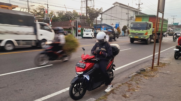 머리 뒤에 헬을 착용한 오토바이를 타는 남자.