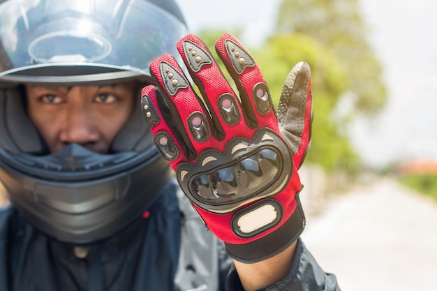 Uomo in una moto con indumenti protettivi casco e guanti