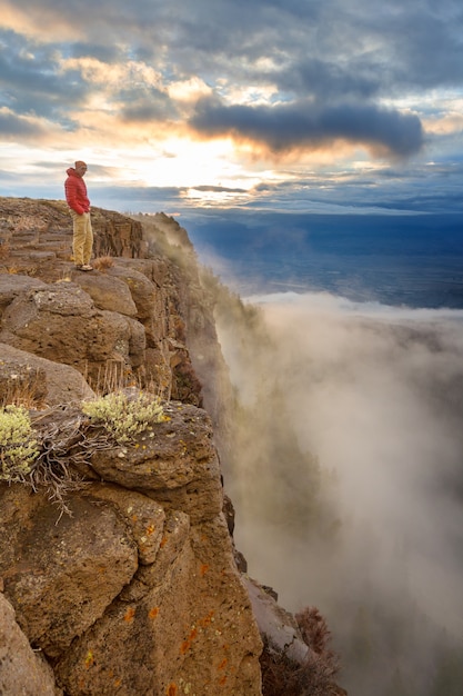 Man on the mountains cliff. Hiking scene.