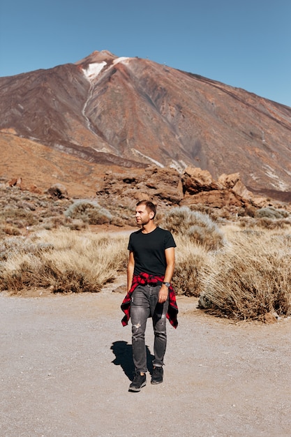 Foto uomo su montagne e vulcano.