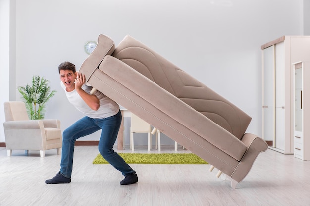 Man moving furniture at home