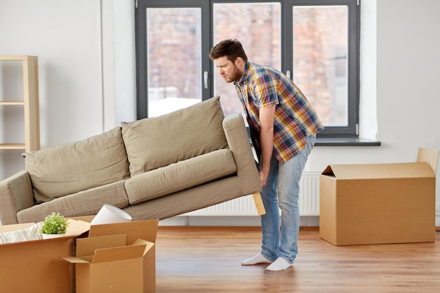 man moving sofa at new home