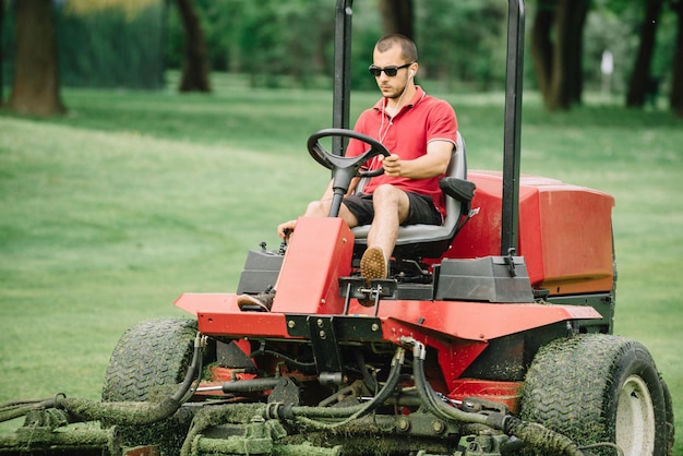 Photo man mowing grassy land