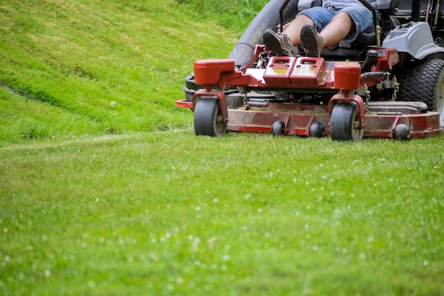 Man mows lawn using gasolinepowered selfpropelled lawn mower on cutting grass with lawn mower