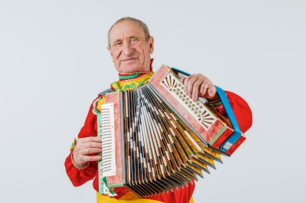 A man in a national costume plays the accordion. Isolated on a white background.