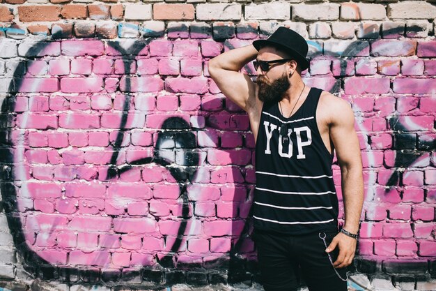 Man near brick graffiti wall