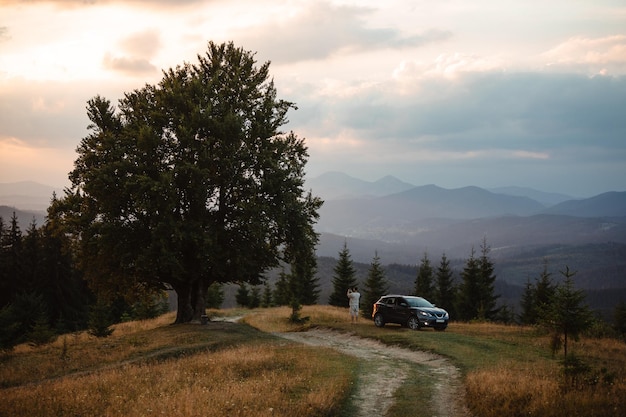 Man near car Sunset in the mountains