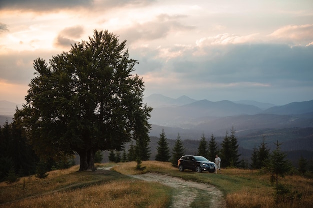 Man near car Sunset in the mountains