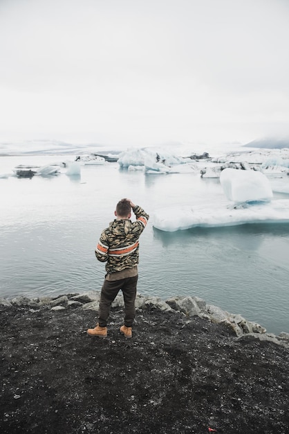 Foto uomo vicino al ghiacciaio in islanda