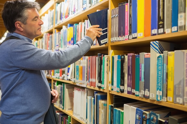 Man neemt een boek uit de schappen