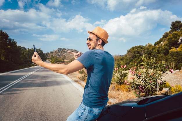 Foto man neemt een selfie terwijl hij op de weg tegen de lucht staat