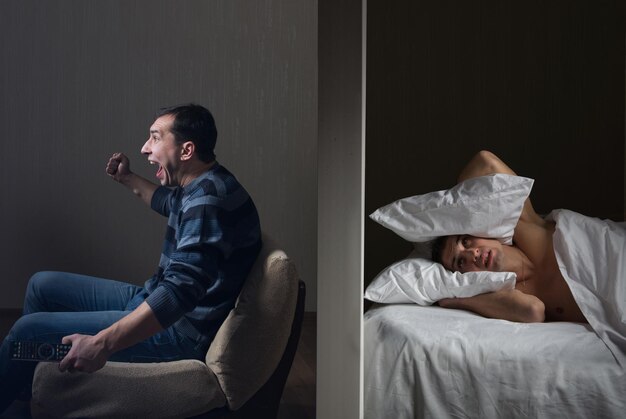 Man at night can't fall asleep because of the noisy neighbor