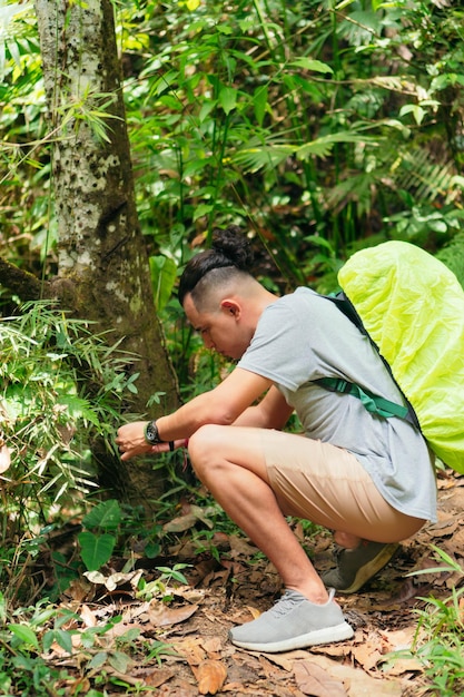 열대 우림에서 식물을 관찰하는 남자