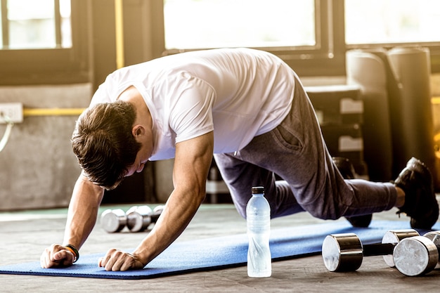 man oefening plank in de sportschool