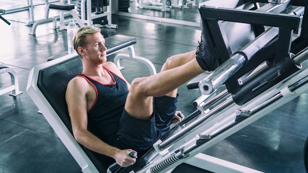 man oefent zijn been op de machine in fitness